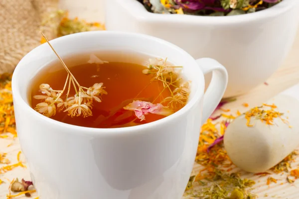 Taza de té saludable, mortero y mortero con hierbas curativas —  Fotos de Stock