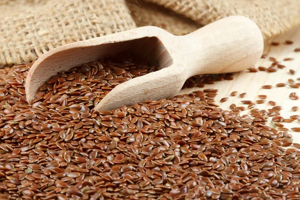 Linseed, flax seeds, wooden scoop, sack — Stock Photo, Image