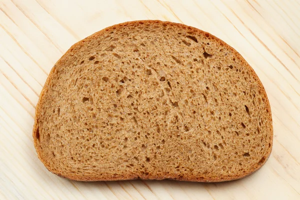 Sneetje brood op houten tafel — Stockfoto