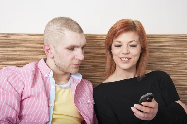 Młoda para patrząca na telefon komórkowy Obraz Stockowy