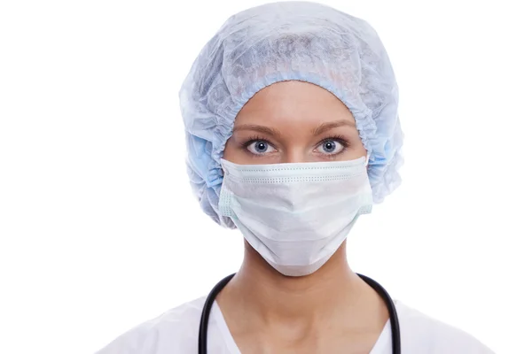 Portret młodej lekarki w fartuchu z maską i czapką — Zdjęcie stockowe