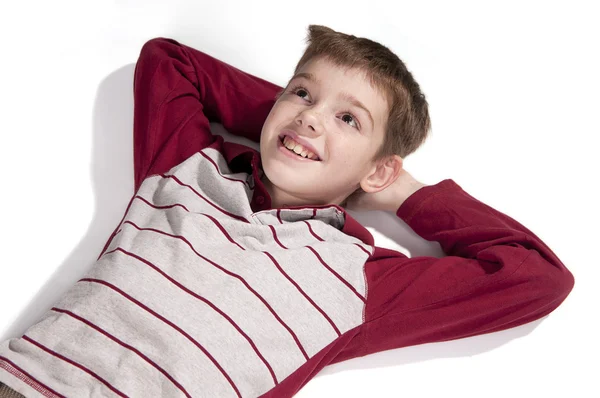Portrett av en gutt som ligger på et hvitt gulv – stockfoto