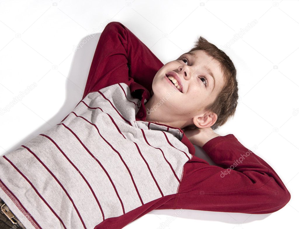Portrait of a boy lying on a white floor