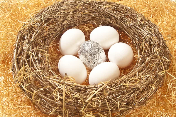 Ein silbernes Folienei mit fünf weißen Eiern — Stockfoto