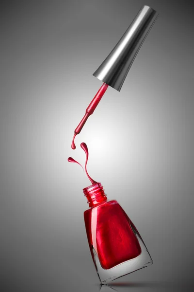 Botella de esmalte de uñas rojo con salpicadura — Foto de Stock