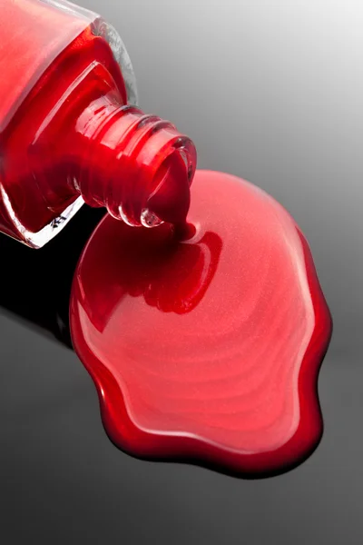 与飞溅的红色指甲油瓶 — 图库照片