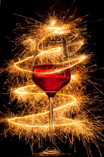 Wine in glass with burning sparklers on black background — Stock Photo, Image