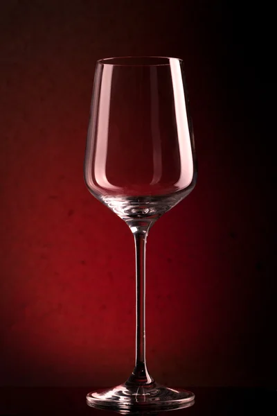 Lege wijnglas op rode achtergrond — Stockfoto