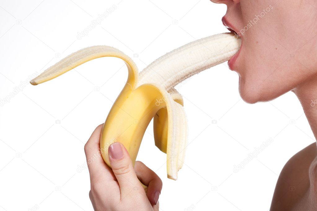 Young woman biting banana isolated on white