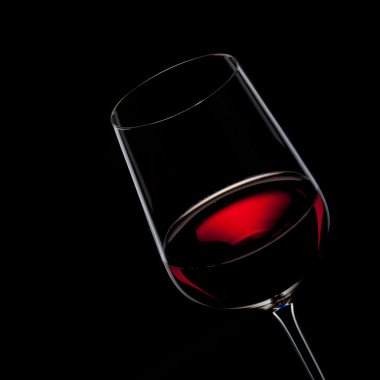 Red wine in glass isolated on black clipart