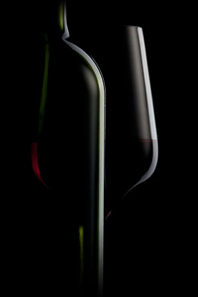 Rode wijn in glas en fles geïsoleerd op zwart — Stockfoto