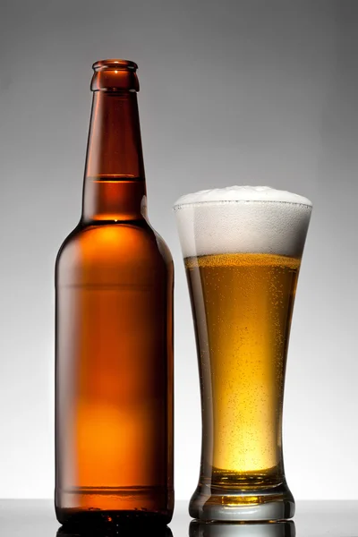 Cerveza en vaso y botella en blanco —  Fotos de Stock