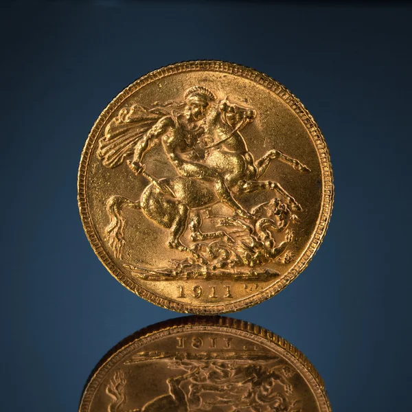 Oude gouden soeverein munt op blauw — Stockfoto