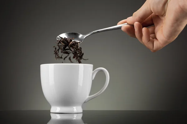 Chá derramar em copo branco no cinza — Fotografia de Stock