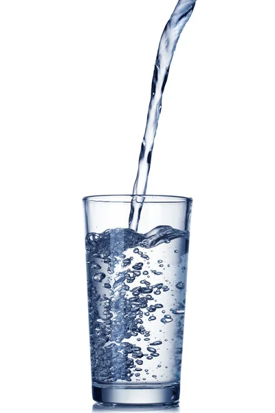 Voda proudí do skla, izolované na bílém — Stock fotografie