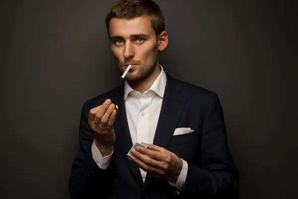 Портрет красивого бизнесмена с сигаретой на черном — стоковое фото