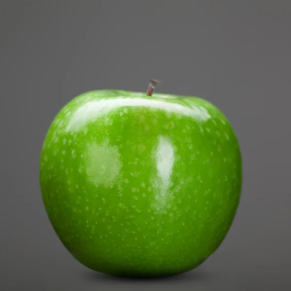 Zielone jabłko na szarym tle — Zdjęcie stockowe