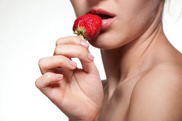 Young woman biting strawberry isolated on white — Stok fotoğraf