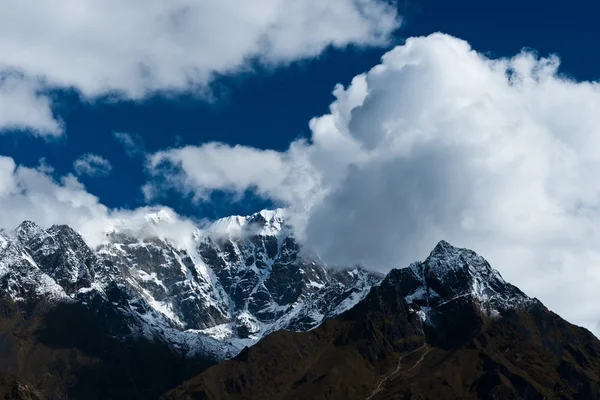Snowed up mountain range and clouds in Himalayas — Stock Photo, Image