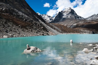 Pebble stacks and Sacred Lake near Gokyo clipart