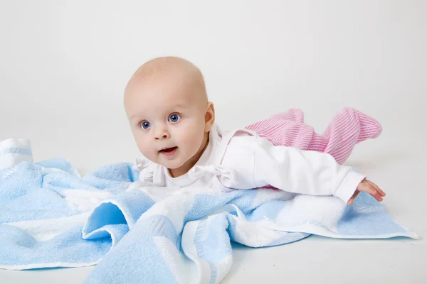 Little girl on a blue towel — Stock Photo, Image