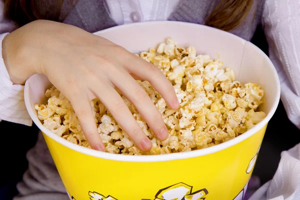 Hand in einem Eimer Popcorn — Stockfoto
