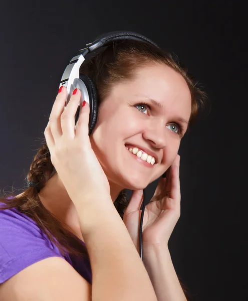 Menina sorridente nos fones de ouvido — Fotografia de Stock