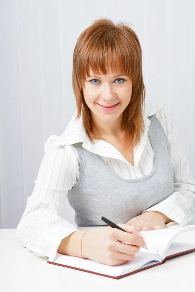 Attractive girl with a notepad and pen — Stock Photo, Image