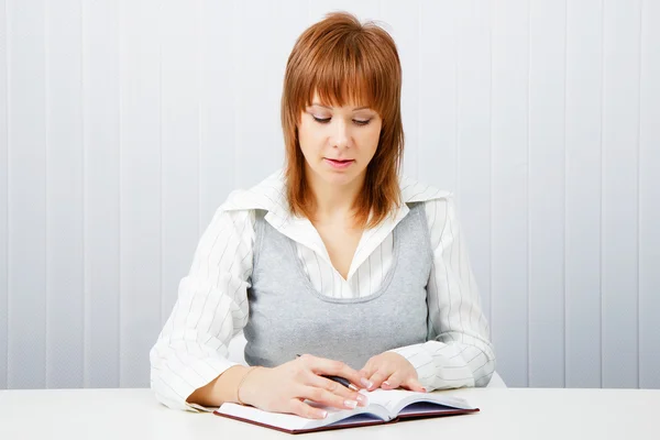 Muchacha atractiva con un bloc de notas y pluma — Foto de Stock