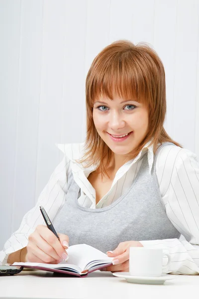 Smiling attractive girl with a notebook — Stock Photo, Image