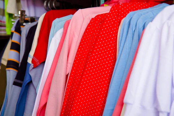 Ljusa barnkläder på en galge i butiken — Stockfoto