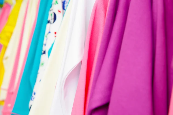 Viele Kleidungsstücke auf einem Kleiderbügel — Stockfoto