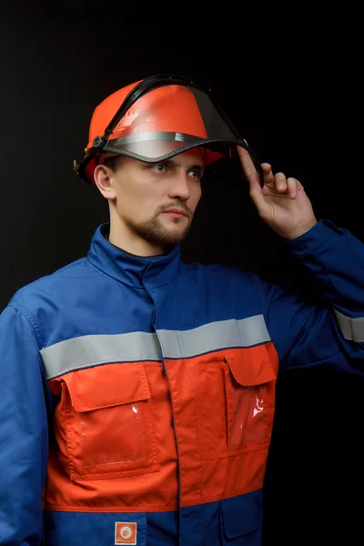 The worker in overalls and a helmet — Stock Photo, Image