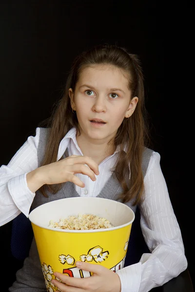 Überrascht Mädchen mit Popcorn auf schwarzem Hintergrund — Stockfoto
