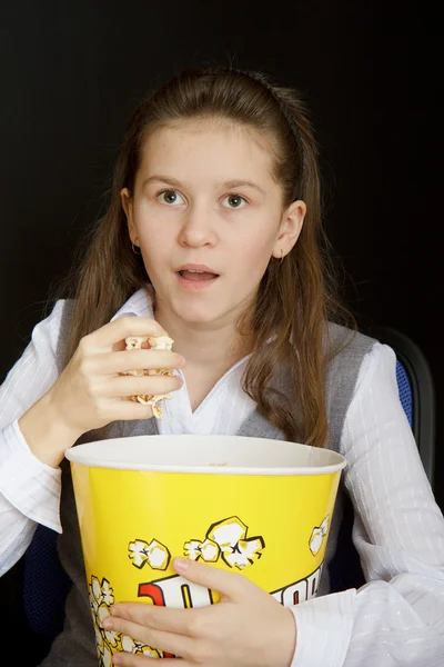 Surprised girl with popcorn on a black background — Stock Photo, Image