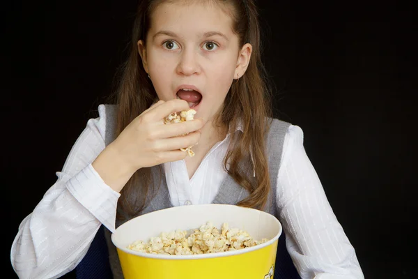 Ragazza sorpresa con popcorn su uno sfondo nero — Foto Stock