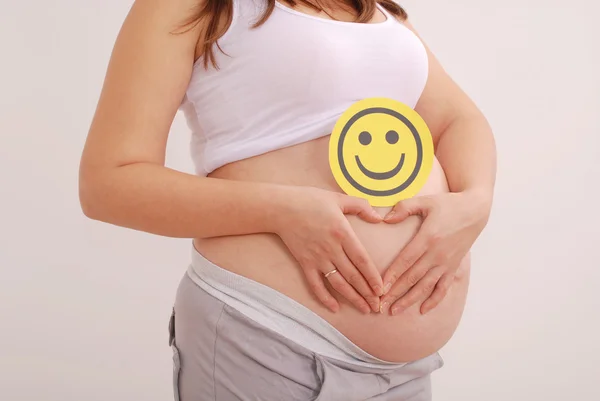 Mujer embarazada apretó sus manos en forma de corazón —  Fotos de Stock