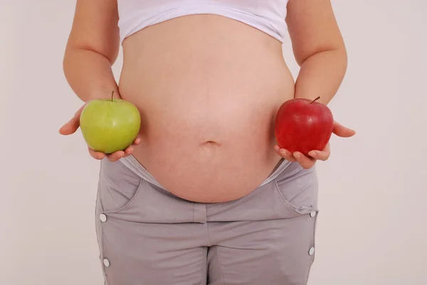 Mujer embarazada sosteniendo manzanas en las manos de —  Fotos de Stock