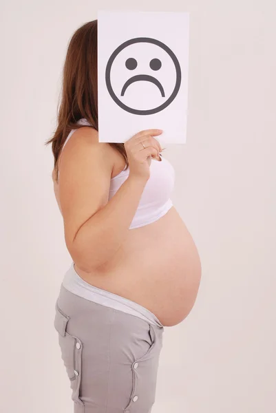 しかめっ面の顔カードと妊娠中の女性. — ストック写真