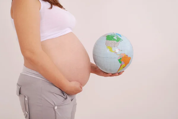 Kobieta w ciąży trzymającego kulę ziemską — Zdjęcie stockowe