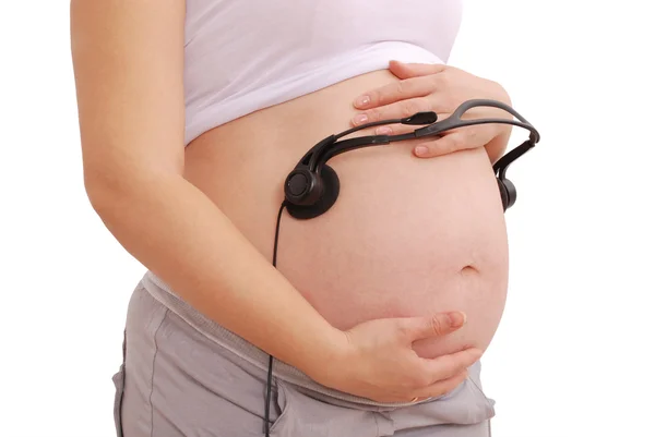 Mulher grávida com fones de ouvido no estômago — Fotografia de Stock