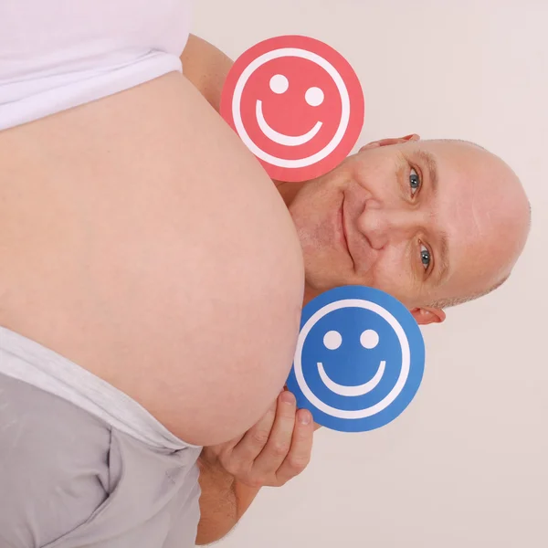 Man looks out from the stomach of his pregnant wife. — Stock Photo, Image