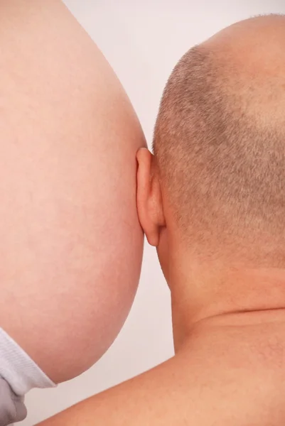 Marido ouve o estômago da esposa grávida — Fotografia de Stock