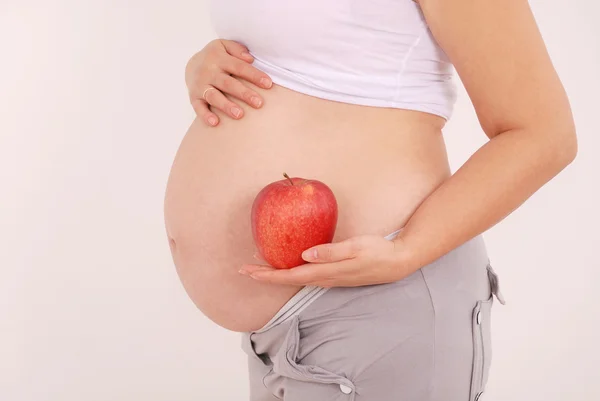 Kobieta w ciąży gospodarstwa jabłka w rękach — Zdjęcie stockowe