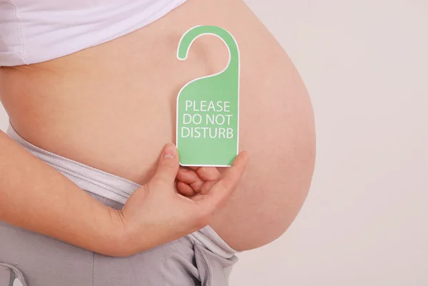 Forstyr ikke skiltet i hans hænder gravid kvinde - Stock-foto
