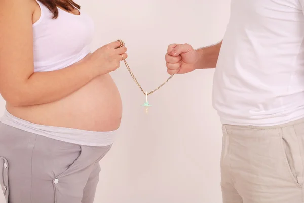 Schwangere und ihr Mann in seinen Händen Attrappen — Stockfoto