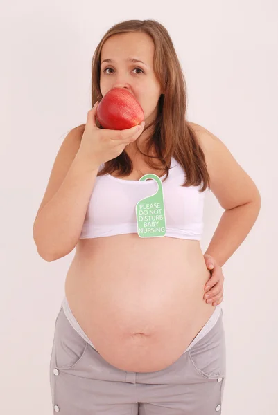 Femme enceinte mangeant une pomme . — Photo