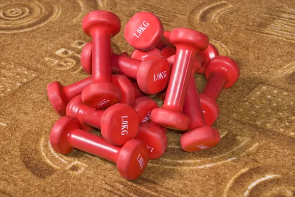 Muitos halteres vermelhos pesando um quilograma — Fotografia de Stock