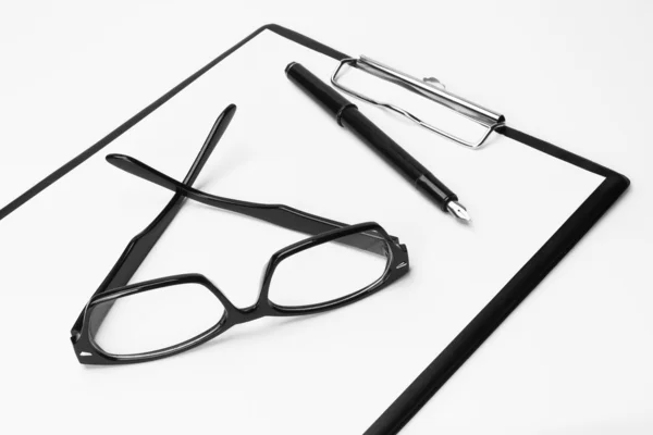 Blank clipboard with pen and eyeglasses — Stock Photo, Image