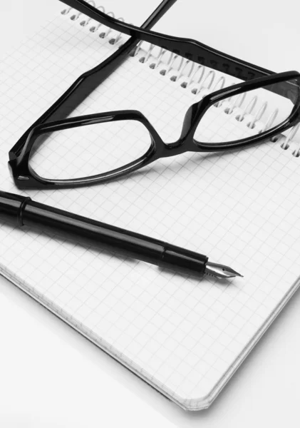 Óculos e caneta, no bloco de notas — Fotografia de Stock
